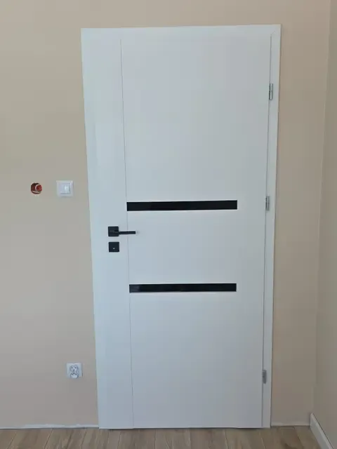 Białe drzwi wewnętrzne z dwoma czarnymi paskami